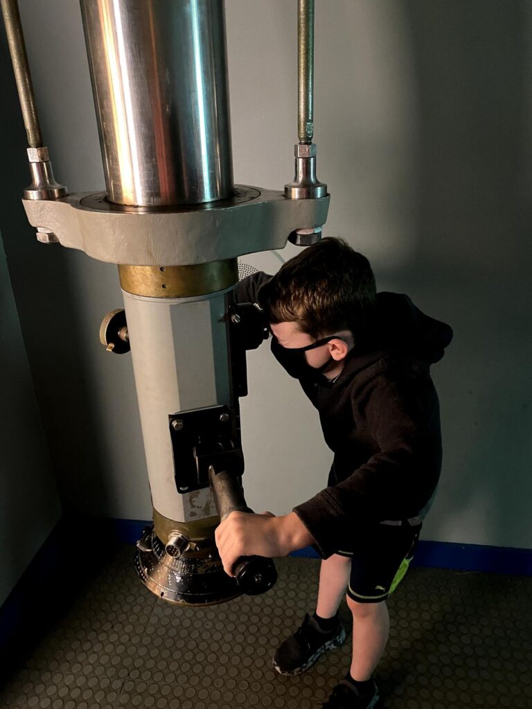 John checks out our surroundings through the periscope. - <i>Photo by the author</i>