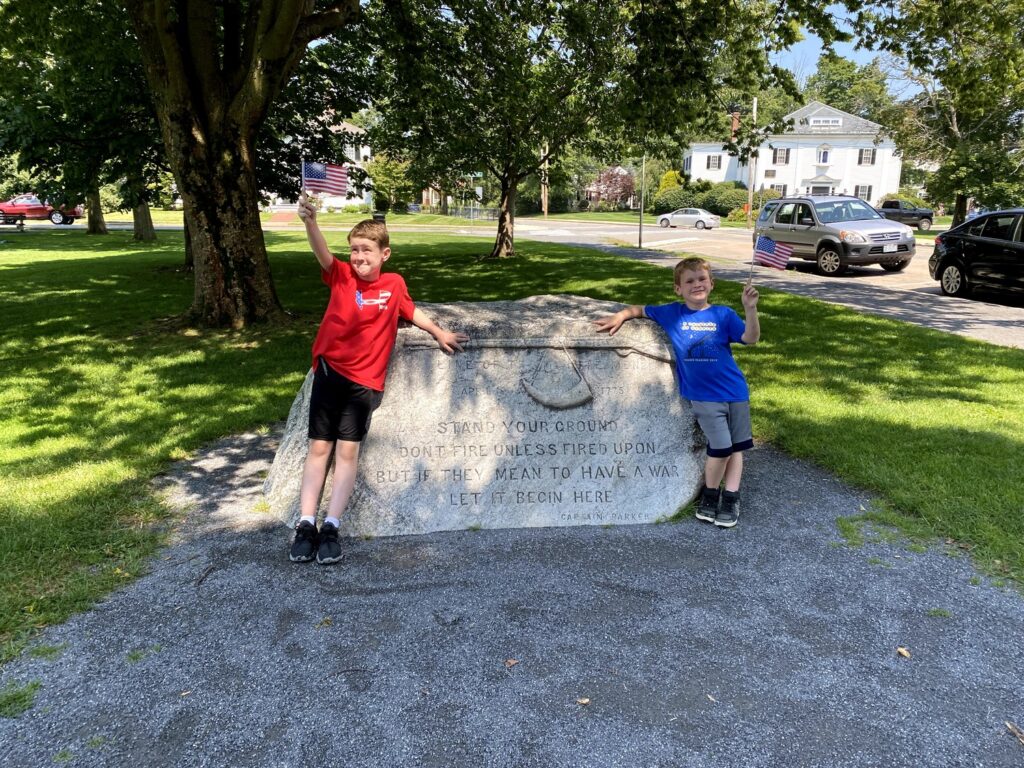Posing with their flags at one of the monuments on Lexington Green. - <i>Photo by the author</i>