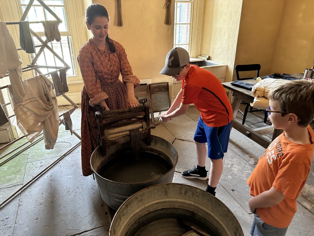Officers serving at the fort brought their families along. Here my boys learn about how laundry was done before the electric washing machine. - <i>Photo by the author</i>
