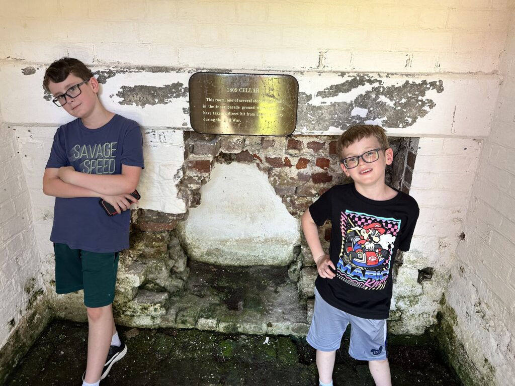 The boys posing with some Civil War battle damage in the fort. - <i>Photo by the author</i>