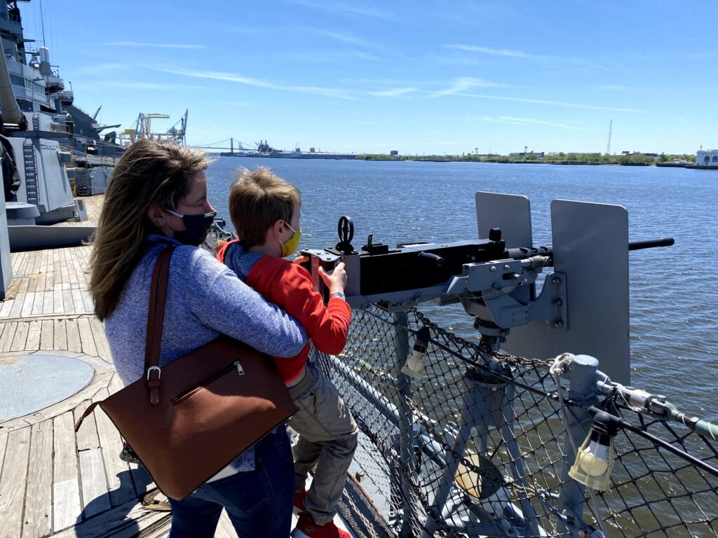 Emily helps Isaac reach the .50 machine gun on the forecastle. - <i>Photo by the author</i>