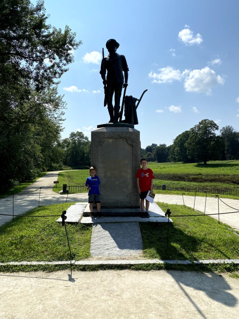 The boys with the Minute Man monument at the Old North Bridge in Concord. - <i>Photo by the author</i>